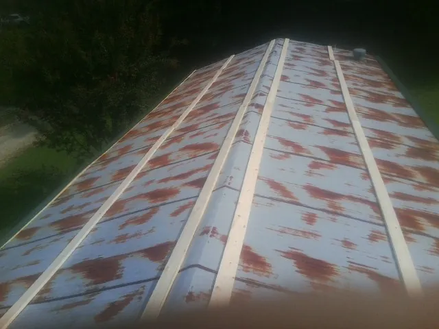 Rusted metal roof panels with new wood purlins before replacement — Storm Damage Roof Repair in Hornell by Roofing Brothers